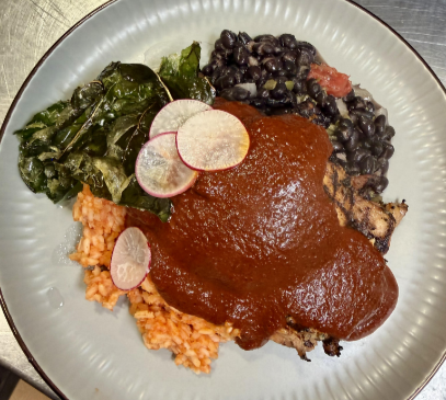 Chicken mole made with romanesco leaves & radishes from Campus Grown